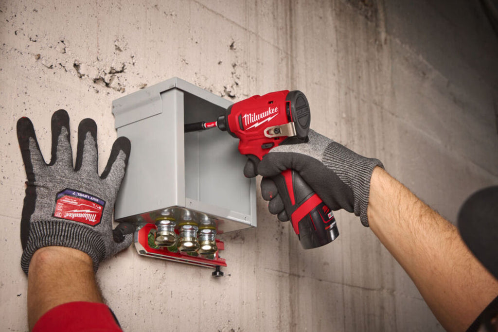 mester folosind o bormasina pentru fixarea in perete a unui contor