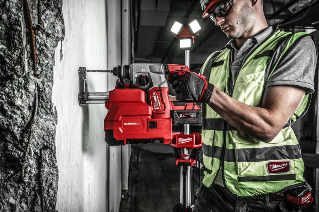 mester folosind un ciocan rotopercutor pentru a gauri beton armat intr-o hala