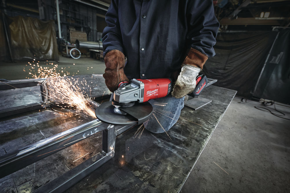 Tăiere metal cu polizor unghiular Milwaukee M18 FUEL, utilizat pentru lucrări de prelucrare și ajustare a structurilor metalice în mediu industrial.