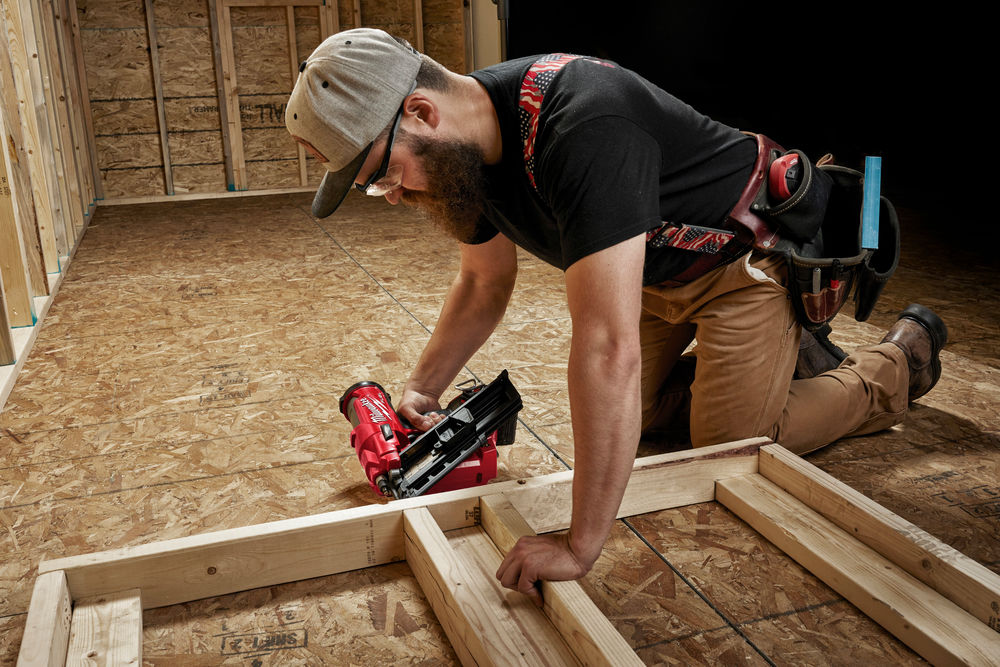 Fixare de cadre din lemn folosind un pistol de bătut cuie Milwaukee M18 FUEL, în timpul construcției structurii unei încăperi.